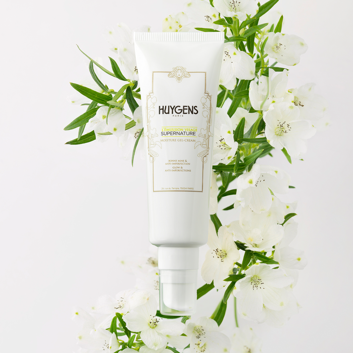 Tube de l'émulsion visage posé parmi des fleurs blanches